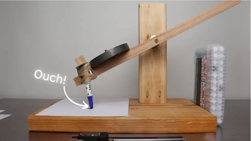 a wooden device with a pen on it